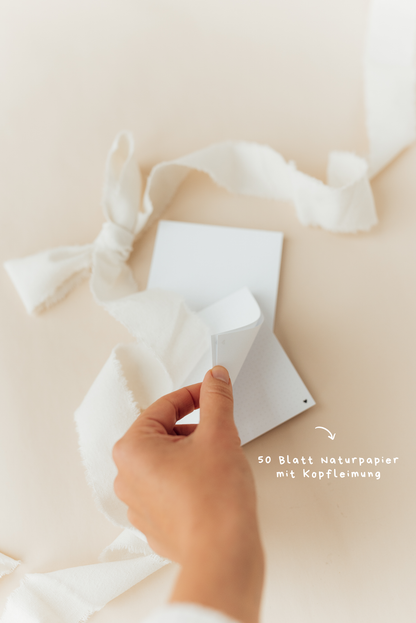 Notizblock Herzchen auf Schreibtisch mit Schleifenband – beherzigt